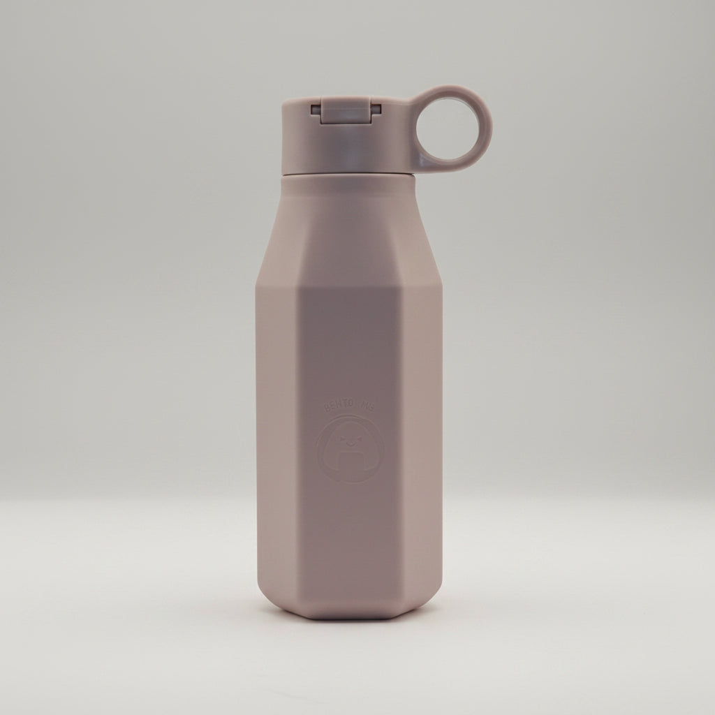 A beige silicone water bottle with a cap and carrying loop, displayed against a bokeh background.