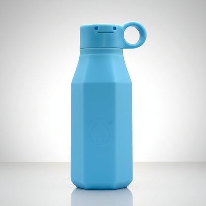 A baby blue silicone water bottle with a pastel color, displayed alongside floral decorations, emphasizing its eco-friendly and reusable attributes.