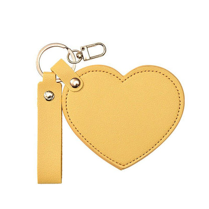 Yellow heart-shaped keychain with a strap on a white background