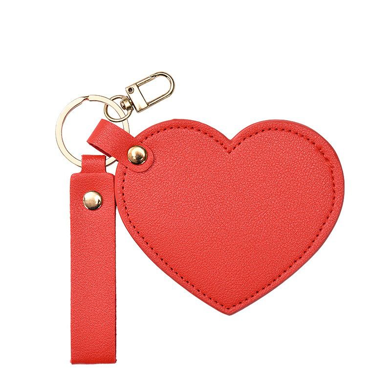 Red heart-shaped keychain with a strap on a white background