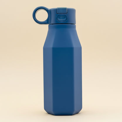 A navy-blue water bottle with a pastel color, displayed alongside floral decorations, emphasizing its eco-friendly and reusable attributes.