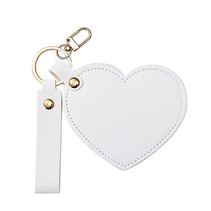 White heart-shaped keychain with a strap on a white background