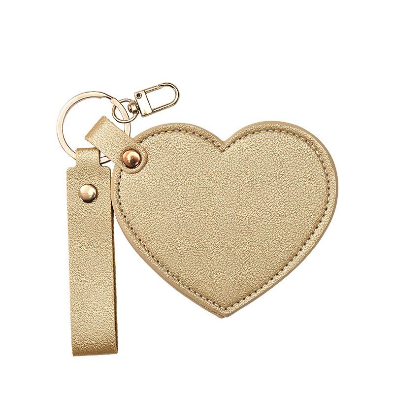 Gold heart-shaped keychain with a strap on a white background